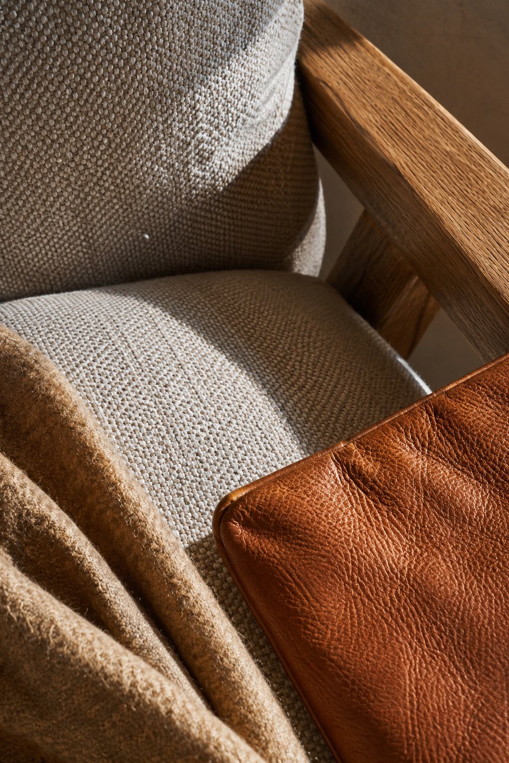Close detail of upholstery textures: woven performance fabric, cognac leather and wool