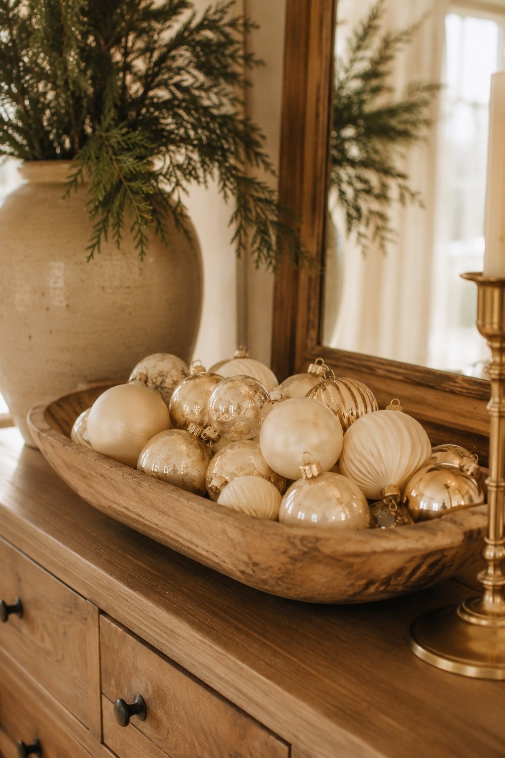 Cream and gold baubles in a wood dough bowl as a holiday centerpiece